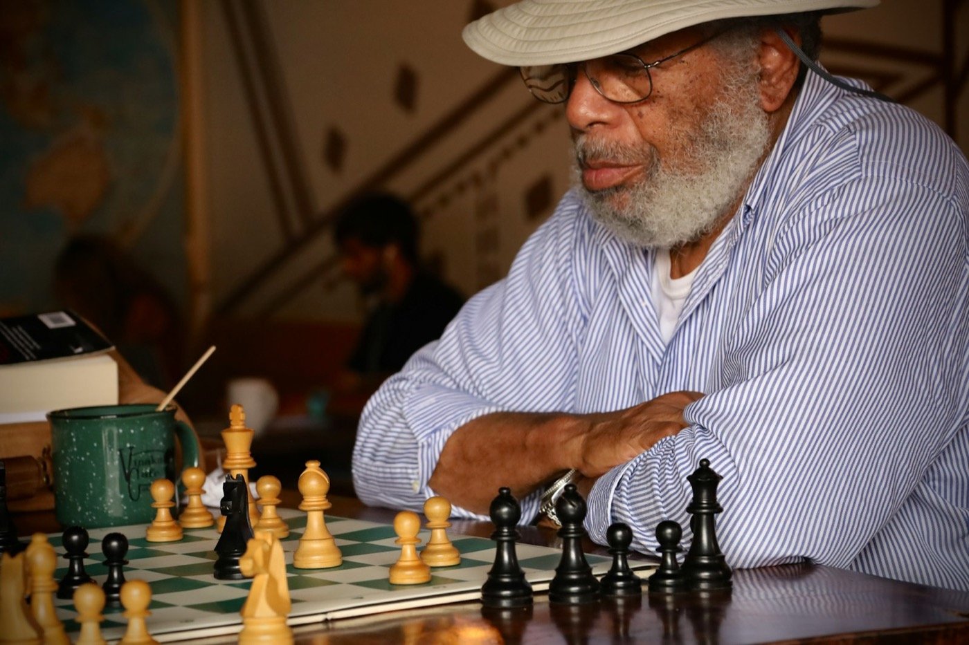 an older man playing chess with a large set of chess pieces